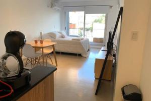 een woonkamer met een tafel en een kamer met een bed bij Amazing apartment with amenities in Buenos Aires