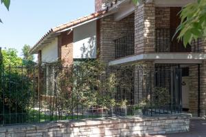 a brick house with a black wrought iron gate at Habitación en La Casa de Mis Padres in Mendoza