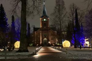 a church with a clock tower at night at City Pearl in Jyväskylä