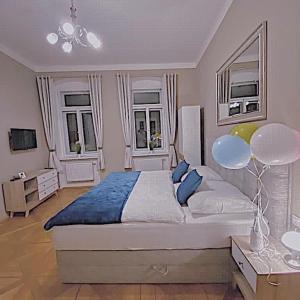 Un dormitorio con una cama grande y dos ventanas. en Apartment Vertigo, en Karlovy Vary