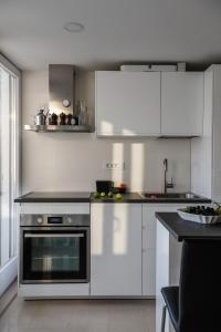 a kitchen with white cabinets and a stove at Penthouse in old Dalmatian house - Flybridge in Hvar