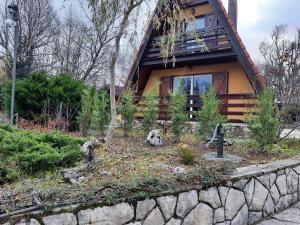 a house with a stone wall in front of it at Planinska kuca Dasovic in Fužine