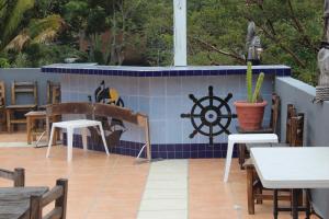a patio with tables and chairs and a tile wall at La Posada Pacifica in Puerto Vallarta