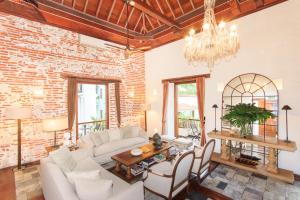 a living room with a brick wall and a chandelier at Hotel Boutique Casa del Coliseo in Cartagena de Indias