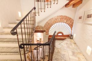 a spiral staircase in a house with a brick wall at Hotel Boutique Casa del Coliseo in Cartagena de Indias