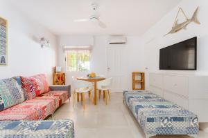 uma sala de estar com um sofá e uma mesa em CASA TORRE Y MAR with 2 bedrooms swimming pool grill & garden & solarium em Torrevieja