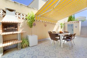 a patio with a table and chairs and a grill at CASA TORRE Y MAR with 2 bedrooms swimming pool grill & garden & solarium in Torrevieja