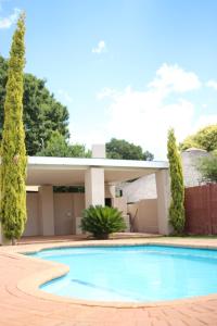 a swimming pool in front of a house at Modern Farm in Lichtenburg