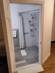 een badkamer met een douche en een glazen deur bij Cadet Motel in Cornwall-on-Hudson