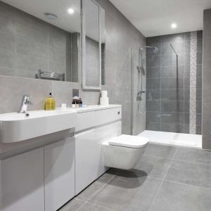 uma casa de banho com um WC, um lavatório e um chuveiro em LuxuStay Serviced Apartments em Milton Keynes