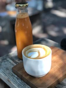 a cup of coffee on a wooden table with a drink at NOAH House in Cape Town
