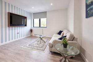uma sala de estar com um sofá e uma televisão em LuxuStay Serviced Apartments em Milton Keynes