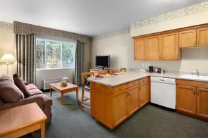 a kitchen and living room with a couch and a table at Ramada by Wyndham Olympia in Olympia