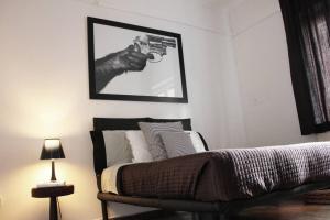 Ein Schlafzimmer mit einem Bild eines Mannes, der eine Waffe hält. in der Unterkunft LOQUAT HOUSE nel giardino segreto in zona Vaticano in Rom