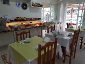 a dining room with two tables with green table cloth at Pousada Morada do Pescador in Bombinhas