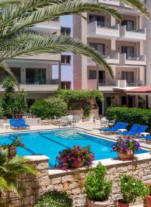 a swimming pool in front of a building at Ilios Beach Hotel Apartments ADULTS ONLY in Rethymno