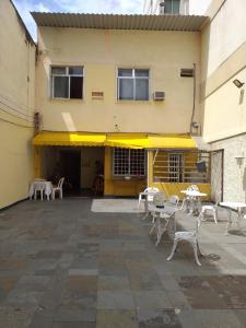 a patio with tables and chairs in front of a building at Hostel Varandas do Maracanã in Rio de Janeiro