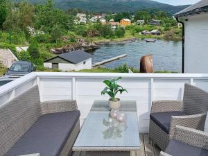 a balcony with a table and chairs and a view of a river at Holiday home TØRRVIKBYGD in Tyrvikbygd
