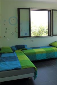 Un dormitorio con dos camas y una ventana. en Etna Holiday Home, en Nicolosi