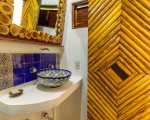 a bathroom with a sink and a mirror at Xcabal Hotel boutique in Bacalar