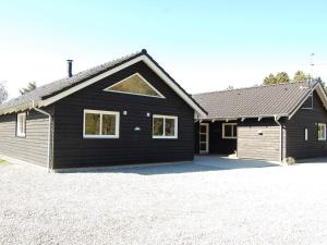 una casa negra con techo de gambrel en Holiday home Blåvand CLX, en Blåvand