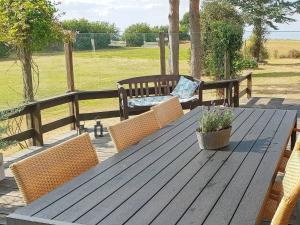 - une table de pique-nique en bois avec des chaises et un banc dans l'établissement 6 person holiday home in Nordborg, à Nordborg