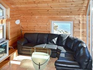 a living room with a leather couch and a table at 6 person holiday home in EIDSVÅG-By Traum in Rød