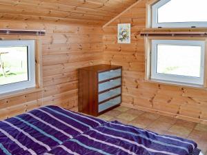a bedroom in a log cabin with two windows at 6 person holiday home in EIDSVÅG-By Traum in Rød +58 photos