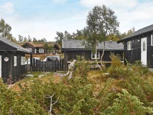 un grupo de casas y un patio con árboles en 6 person holiday home in Rennebu en Sundset