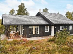 a small black house with a patio in front of it at 6 person holiday home in Rennebu in Sundset