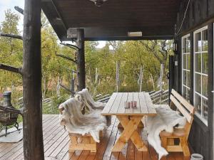 a wooden table and chairs on a wooden deck at 6 person holiday home in Rennebu in Sundset