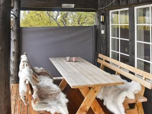 a wooden table and benches on a porch with two dogs at 6 person holiday home in Rennebu in Sundset