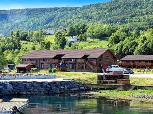 EidsvågにあるSix-Bedroom Holiday home in Eidsvågの水の隣の丸太小屋