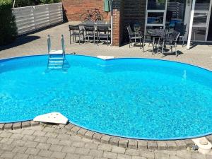 a large blue swimming pool with a chair in it at 8 person holiday home in H jslev in Bøstrup