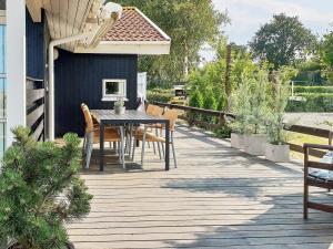 une terrasse en bois avec une table et des chaises sur une maison dans l'établissement 6 person holiday home in Nordborg, à Nordborg