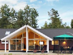 eine abgeschirmte Veranda mit Stühlen und einem Tisch in der Unterkunft Two-Bedroom Holiday home in Hornbæk 2 in Rødby