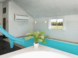 y baño con bañera y palmera. en 20 person holiday home in L kken, en Løkken