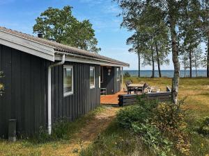 a black house with a patio and a table at 8 person holiday home in Nex in Snogebæk
