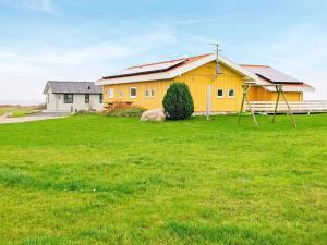 ノーポにある8 person holiday home in Nordborgの緑草の黄色い家
