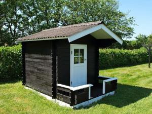 a small black out house with a white door at 8 person holiday home in Hemmet in Hemmet