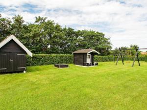 a playground with a small shack and a swing at 8 person holiday home in Hemmet in Hemmet