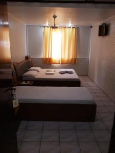 a bedroom with two beds and a window at Hotel Mustang in São Paulo