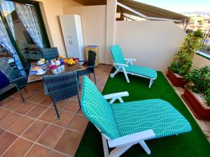 a patio with chairs and a table and a table and chairs at Los Geranios 21 Tenerife in Costa Del Silencio +65 photos