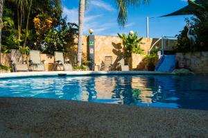 una piscina in un resort con sedie e palme di Oceans Two Resort a Manuel Antonio
