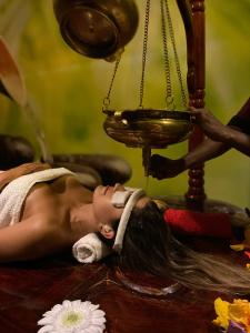 a woman laying on a table while getting her hair washed at Fun Retreat Resort, Hotel and Ayurveda Spa in Arusha