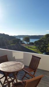 eine Terrasse mit einem Tisch und 2 Stühlen auf einem Balkon in der Unterkunft Jake's Place Oneroa Waiheke in Oneroa