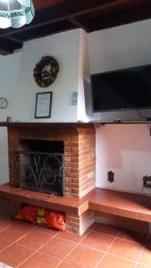 a living room with a fireplace and a flat screen tv at Chalés Lauterbrunnen in Monte Verde