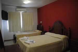 a hotel room with two beds with towels on them at Hotel La Toscana in Villa Carlos Paz