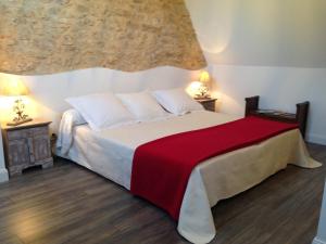 a bedroom with a large bed with a red blanket at Les Camelias in Lalinde