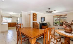 eine Küche und ein Esszimmer mit einem Holztisch und Stühlen in der Unterkunft Banya Bliss - Guest House in Bongaree